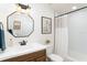 Bathroom features a wooden vanity, shower with white subway tile, and stylish mirror at 2910 W Aquilla St, Tampa, FL 33629