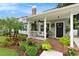 Charming home featuring a brick front porch and beautifully landscaped yard with vibrant plants and a welcoming entrance at 2910 W Aquilla St, Tampa, FL 33629