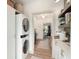 Convenient laundry area with stacked washer and dryer, shelving, and a view into the kitchen at 2910 W Aquilla St, Tampa, FL 33629