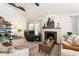 Cozy living room with a fireplace, wood floors, comfortable seating, and a seamless flow to foyer at 2910 W Aquilla St, Tampa, FL 33629