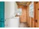 Functional laundry room with stacked washer and dryer, ample window light, and wooden walls at 2920 E 20Th Ave, Tampa, FL 33605