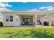 Backyard view showcasing a covered patio and green lawn at 30174 Southernwood Ct, Wesley Chapel, FL 33543
