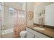Bright bathroom features a shower-tub combo, modern vanity with a stone countertop, and ample lighting at 30174 Southernwood Ct, Wesley Chapel, FL 33543