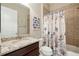 Bathroom with granite vanity, decorative shower curtain, and tiled shower at 30174 Southernwood Ct, Wesley Chapel, FL 33543