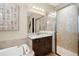 Bathroom featuring granite counters, dark cabinets, shower, and soaker tub at 30174 Southernwood Ct, Wesley Chapel, FL 33543