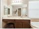 Bathroom featuring granite counters, dark cabinets, bathtub, and large mirror at 30174 Southernwood Ct, Wesley Chapel, FL 33543