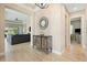 Elegant foyer with wood-look tile flooring, decorative cabinet, and seamless flow to the living area at 30174 Southernwood Ct, Wesley Chapel, FL 33543