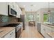 Bright kitchen with modern appliances, granite countertops, and an adjacent dining area with backyard view at 30174 Southernwood Ct, Wesley Chapel, FL 33543