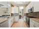 Well-lit kitchen with stainless steel appliances, granite countertops, and a view into the adjacent living area at 30174 Southernwood Ct, Wesley Chapel, FL 33543