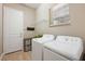 Bright laundry room with white washer and dryer, storage shelves, and a window at 30174 Southernwood Ct, Wesley Chapel, FL 33543