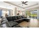 Open-concept living room with a large sectional, tile floors, and sliding doors to an outdoor patio at 30174 Southernwood Ct, Wesley Chapel, FL 33543