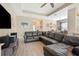 Spacious living room with tile floors, a large sectional sofa, and an open view to the dining area at 30174 Southernwood Ct, Wesley Chapel, FL 33543