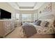 Bright and airy main bedroom featuring tray ceiling and decor at 30174 Southernwood Ct, Wesley Chapel, FL 33543