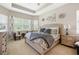 Beautiful main bedroom featuring tray ceiling, decorative pillows, and floral accents at 30174 Southernwood Ct, Wesley Chapel, FL 33543