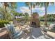 Outdoor lounge area with comfortable seating, a stone fireplace, and a tranquil setting perfect for relaxation at 30174 Southernwood Ct, Wesley Chapel, FL 33543
