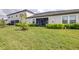 Expansive backyard with lush green grass, manicured landscaping, and a covered porch at 31408 Cabana Rye Ave, San Antonio, FL 33576