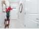 Bright entryway with tiled floor, adorned with decorative mirrors, a decorative flower arrangement, and a white front door at 31408 Cabana Rye Ave, San Antonio, FL 33576