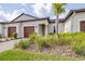 Charming home exterior with two-car garage, well-maintained landscaping, and lush tropical plants at 31408 Cabana Rye Ave, San Antonio, FL 33576