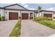 Charming home showcasing a neatly paved driveway leading to its two-car garage and freshly manicured lawn at 31408 Cabana Rye Ave, San Antonio, FL 33576