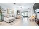 Bright living room features a large sectional sofa, stylish decor, and sliding glass doors to the lanai at 31408 Cabana Rye Ave, San Antonio, FL 33576