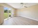 Bright bedroom with sliding glass door leading to backyard, light wood floors, and a ceiling fan at 3252 Scorecard Dr, New Port Richey, FL 34655