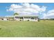 Exterior view of home with a large front lawn, carport, and mature landscaping at 3252 Scorecard Dr, New Port Richey, FL 34655