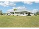 Back exterior of home with a large lawn, mature landscaping, and light-colored stucco siding at 3252 Scorecard Dr, New Port Richey, FL 34655
