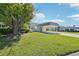 Well-manicured lawn surrounds this home's exterior with a covered carport and mature tree at 3252 Scorecard Dr, New Port Richey, FL 34655