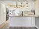 Modern white kitchen featuring granite countertops, stainless steel appliances, and a kitchen island at 3252 Scorecard Dr, New Port Richey, FL 34655