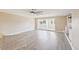 Large living area with a fan, neutral paint, and access to a sunny enclosed patio at 3252 Scorecard Dr, New Port Richey, FL 34655