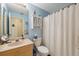 Bright bathroom features a vanity with a beige countertop and a shower behind a white curtain at 3254 Lori Ln, New Port Richey, FL 34655