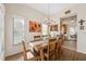 Bright dining room with a large window, chandelier, wood table, and open access to the kitchen at 3254 Lori Ln, New Port Richey, FL 34655