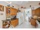 A cozy kitchen with wood cabinets, granite countertops, and views into the sunlit dining area at 3254 Lori Ln, New Port Richey, FL 34655