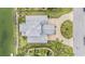 Birds eye view showcases a meticulously landscaped home with a lush green lawn and circular driveway at 3432 Bluefish Dr, Hernando Beach, FL 34607