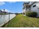 Manicured lawn extends to a chain-link fence by the water, with the house visible in the background at 3432 Bluefish Dr, Hernando Beach, FL 34607