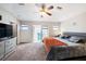 Large main bedroom boasts ceiling fan, carpet floors, slider doors and adjacent primary bathroom at 3432 Bluefish Dr, Hernando Beach, FL 34607