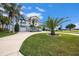 Exterior view of a two-story home with a well-manicured lawn and a circular driveway at 3432 Bluefish Dr, Hernando Beach, FL 34607