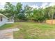 Large backyard featuring a wooden fence and mature trees, offering privacy and space at 3502 Bloomingdale Ave, Valrico, FL 33596