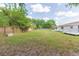 Large, grassy backyard with a wooden fence, offering privacy and space for outdoor activities at 3502 Bloomingdale Ave, Valrico, FL 33596
