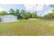 Large, grassy backyard featuring a detached two-car garage at 3502 Bloomingdale Ave, Valrico, FL 33596