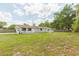 Wide backyard with well-maintained grass, home, and mature trees at 3502 Bloomingdale Ave, Valrico, FL 33596