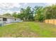 The backyard featuring lush green grass, trees, and wooden fence at 3502 Bloomingdale Ave, Valrico, FL 33596