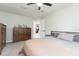 Inviting bedroom with neutral tones, ceiling fan, and ample storage space in classic wood furniture at 3502 Bloomingdale Ave, Valrico, FL 33596
