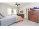 Bedroom showcases a bed, dresser with a TV, and a doorway to the bathroom, with hats hanging on the wall at 3502 Bloomingdale Ave, Valrico, FL 33596