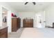 This bedroom has dark wood dressers, access to a walk-in closet, and an open doorway to the rest of the home at 3502 Bloomingdale Ave, Valrico, FL 33596