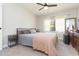 Bright bedroom features a ceiling fan, a bed, and a dresser, with natural light streaming through the window at 3502 Bloomingdale Ave, Valrico, FL 33596