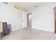 Empty bedroom with tan carpet features an open door, a Hot Wheels decal, and one dark wood dresser at 3502 Bloomingdale Ave, Valrico, FL 33596