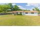 Charming single-story home featuring a bright red door and a spacious, well-maintained front yard with mature trees at 3502 Bloomingdale Ave, Valrico, FL 33596