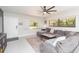 Bright living room featuring a modern ceiling fan, neutral walls, and natural light from large windows at 3502 Bloomingdale Ave, Valrico, FL 33596