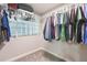 Spacious walk-in closet with ample hanging space and a glass block window providing natural light at 3502 Bloomingdale Ave, Valrico, FL 33596